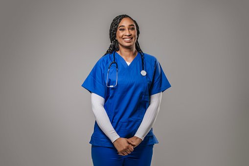 A clinician in blue scrubs with a stethoscope