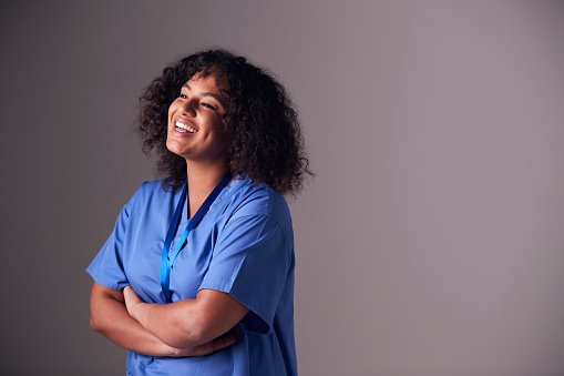 A clinician in blue scrubs laughing