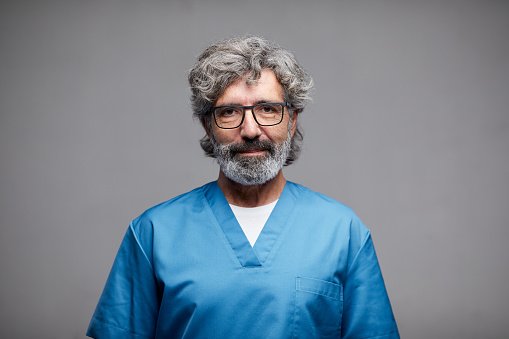 An experienced doctor in blue scrubs