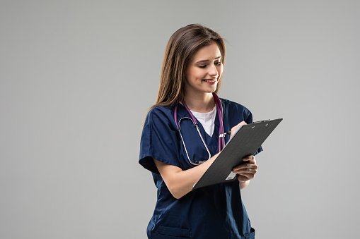 A smiling clinician holding a clipboard
