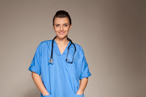 A clinician in blue scrubs with a stethoscope