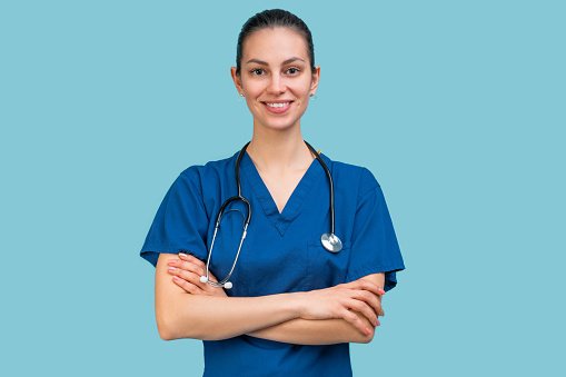 A clinician in teal scrubs with arms crossed