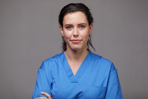 A younger doctor in blue scrubs