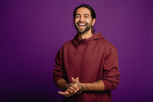 A man in a maroon top, smiling