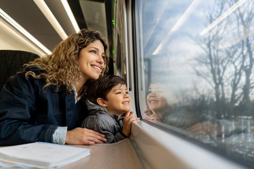 A parent and child looking out of a train window