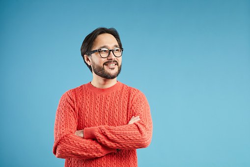 A doctor in a red jumper with arms crossed