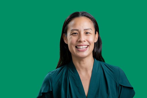 A doctor in a teal top, smiling
