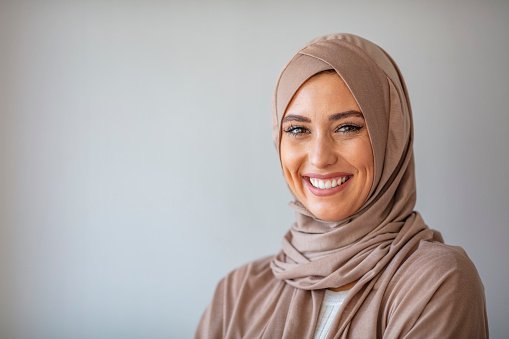 A doctor wearing a tan hijab, smiling