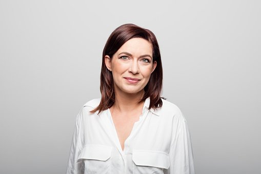 A doctor in a white blouse, smiling