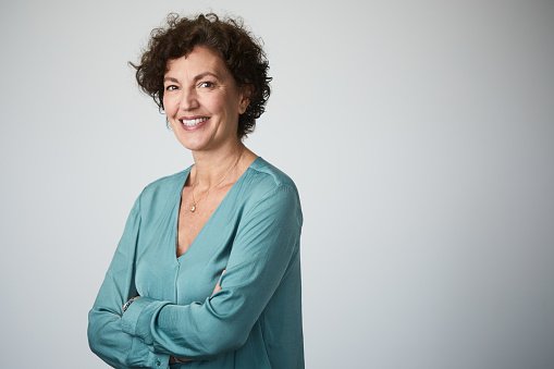 A doctor with curly hair, arms crossed