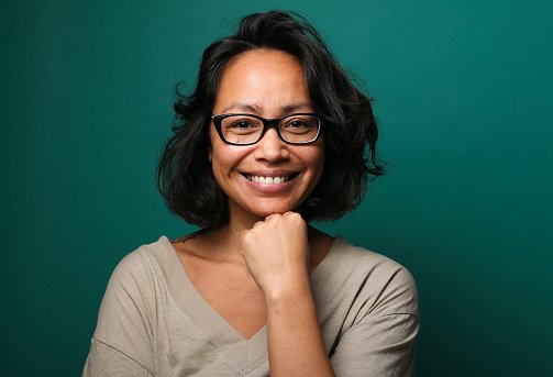 A doctor in glasses with a hand on chin