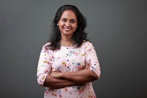 A doctor in a floral top with arms crossed