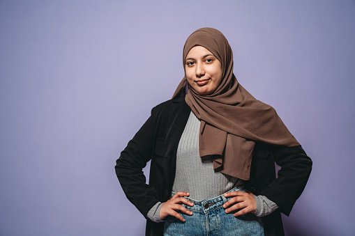 A doctor wearing a hijab with hands on hips